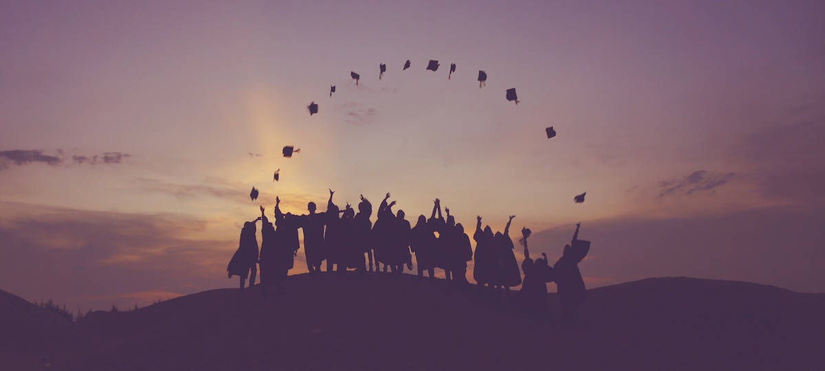 College graduates throwing mortarboards in the air