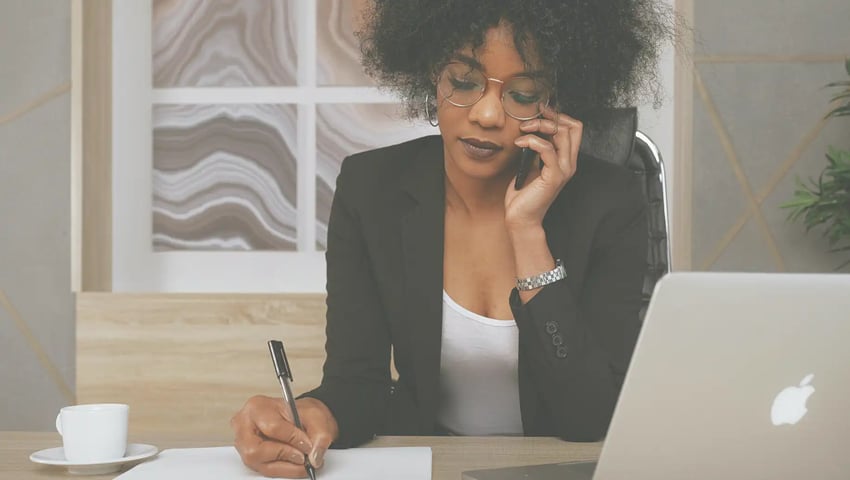 A woman in a black blazer holding a smartphone is learning how exclusive leads could be a game-changer for her insurance agency.