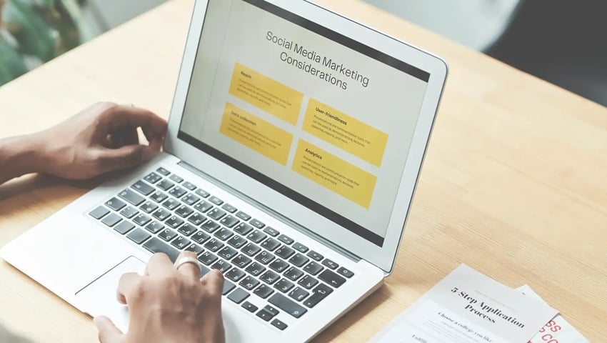 A close-up shot of a person using a laptop to find the best insurance agency marketing tips