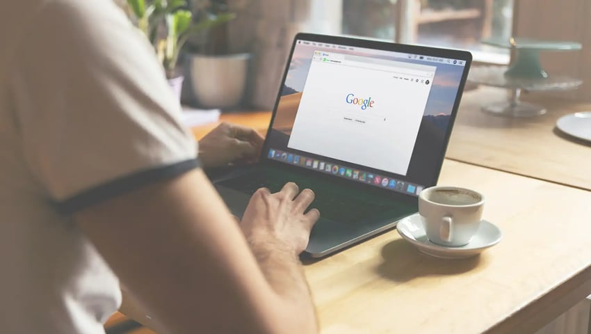 Person using laptop to discover the impact of paid ads on insurance agency marketing