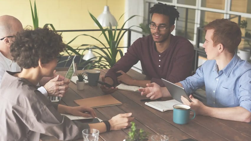 What should you do with a team member who isn’t producing? - Team members leaning on wooden table
